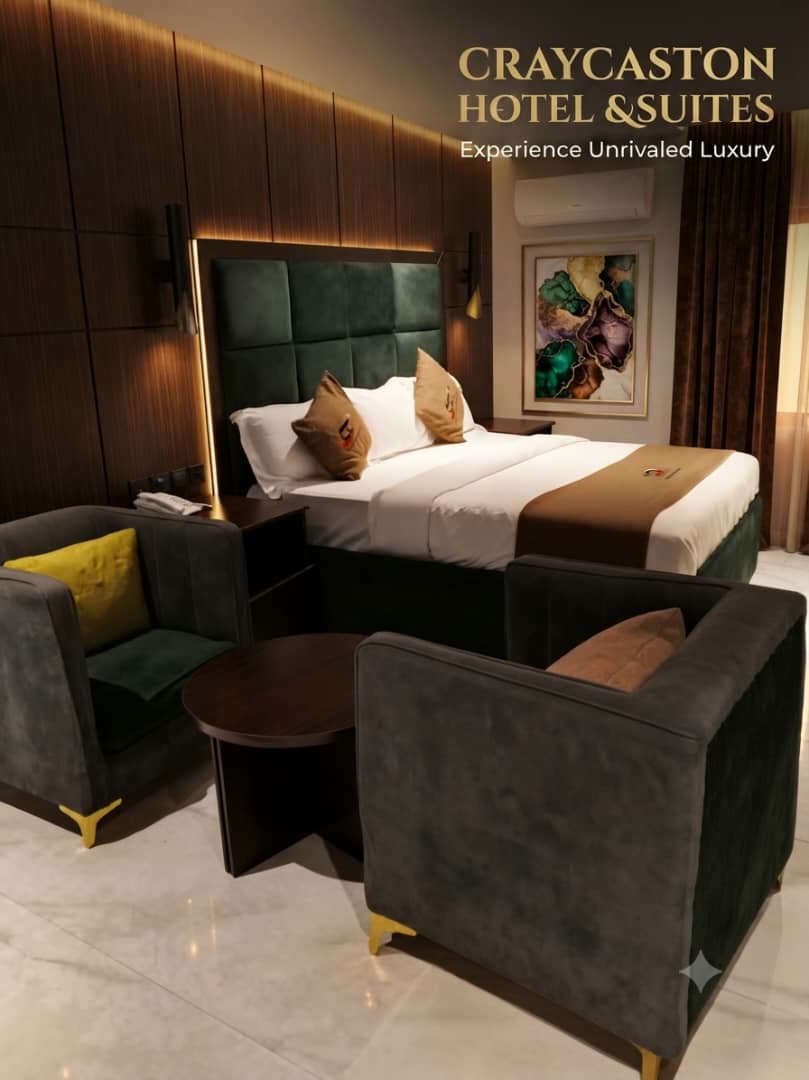King room with a green velvet headboard and a seating pair