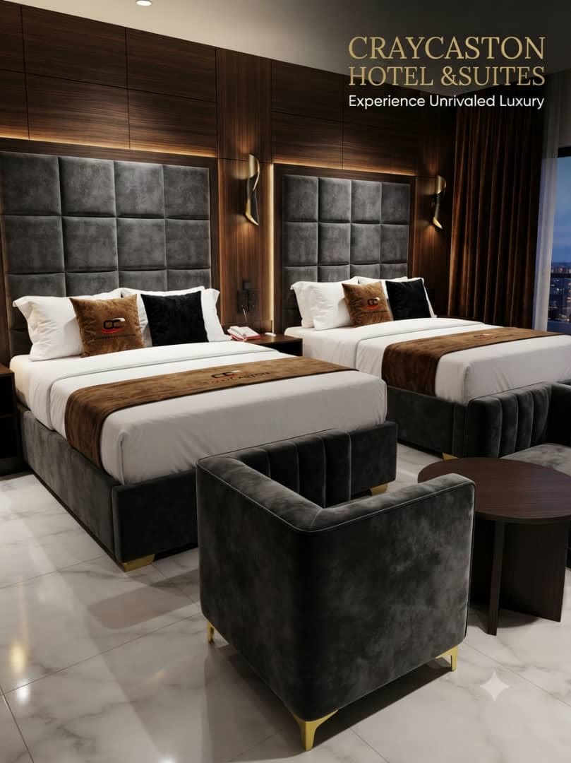 Twin king beds with padded headboards and a velvet armchair