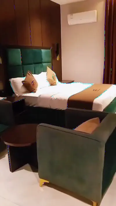 Inside a suite — bed, work desk, smart TV and marble bathroom
